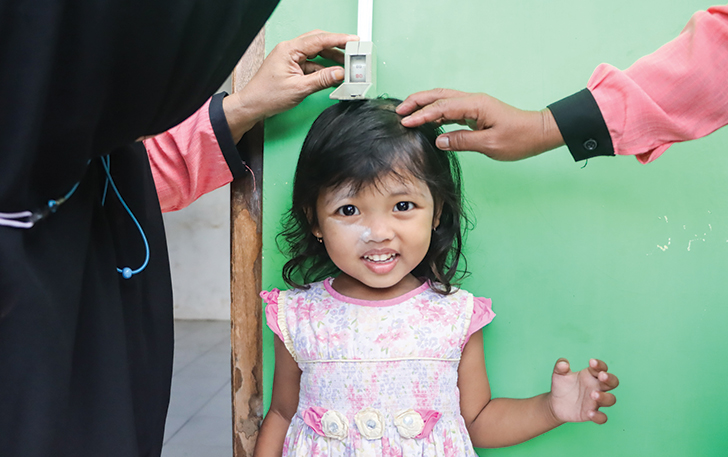 DICEK: Seorang anak tengah dicek tinggi badannya  di Posyandu Singosari, Banyuanyar, Banjarsari, kemarin.