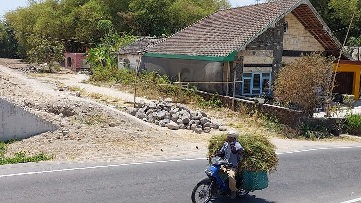Akses jalan untuk dua rumah yang sebagian tertutup material batu proyek saluran air jalan tol Solo-Jogja.