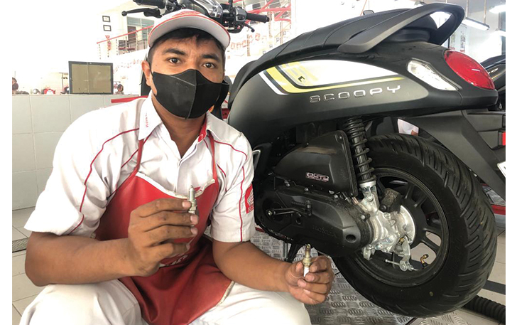 Mekanik dari bengkel resmi AHASS usai memeriksa kondisi busi motor.