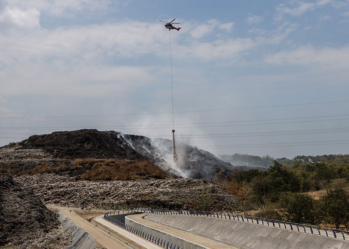Helikopter terus menyemprotkan air dari udara untuk memadamkan titik api di TPA Putri Cempo.