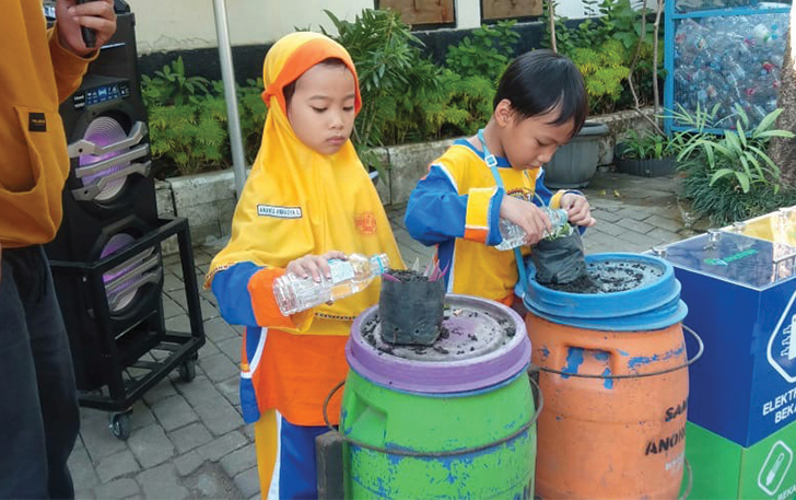 MENAMBAH WAWASAN: Siswa salah satu SD swasta di Kota Solo outing class dengan memupuk tanaman pakai kompos di kantor DLH Kota Surakarta, belum lama ini.