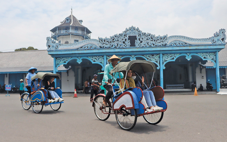 INSTAGRAMABLE: Wisatawan tengah melintasi bangunan Keraton Kasunanan Surakarta dengan menaiki becak.