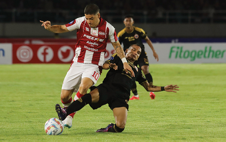 BERJIBAKU: Gelandang Persis Solo Alexis Messidoro (kiri) berebut bola dengan winger Persija Jakarta Riko Simanjuntak di Stadion Manahan, kemarin.