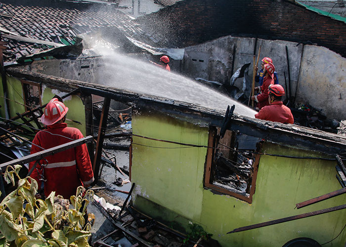 Petugas Dinas Damkar Kota Solo memadamkan api yang membakar rumah warga di Kelurahan Gajahan, Pasar Kliwon, Solo, Kamis (5/10).