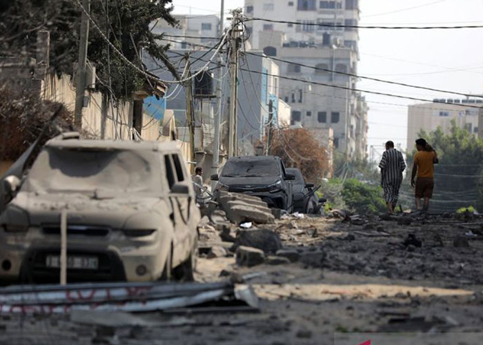 Pria Palestina berjalan di tengah reruntuhan sekolah UNRWA di Kota Gaza, yang hancur semalam akibat serangan udara Israel pada 8 Oktober lalu.