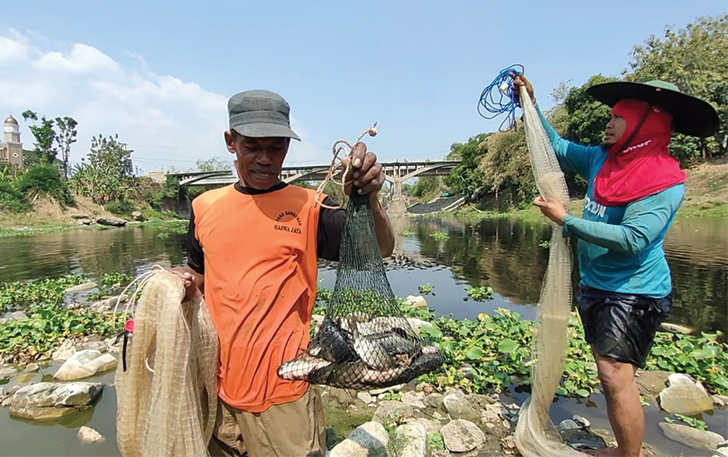 NEKAT: Warga Desa Katelan, Kecamatan Tangen mencari ikan di Sungai Bengawan Solo, pekan lalu. Inset, warga menunjukkan hasil tangkapan ikan.