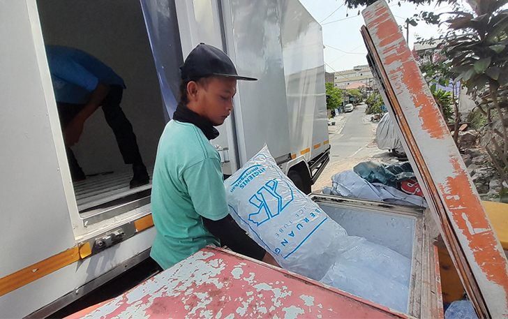 DIBURU: Karyawan agen es kristal di Kelurahan Jebres tengah memasukan stok esnya.