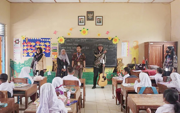 TERUS GAUNGKAN SENI: Anggota Komunitas Yuk Belajar Seni membimbing anak-anak SD belajar soal seni.