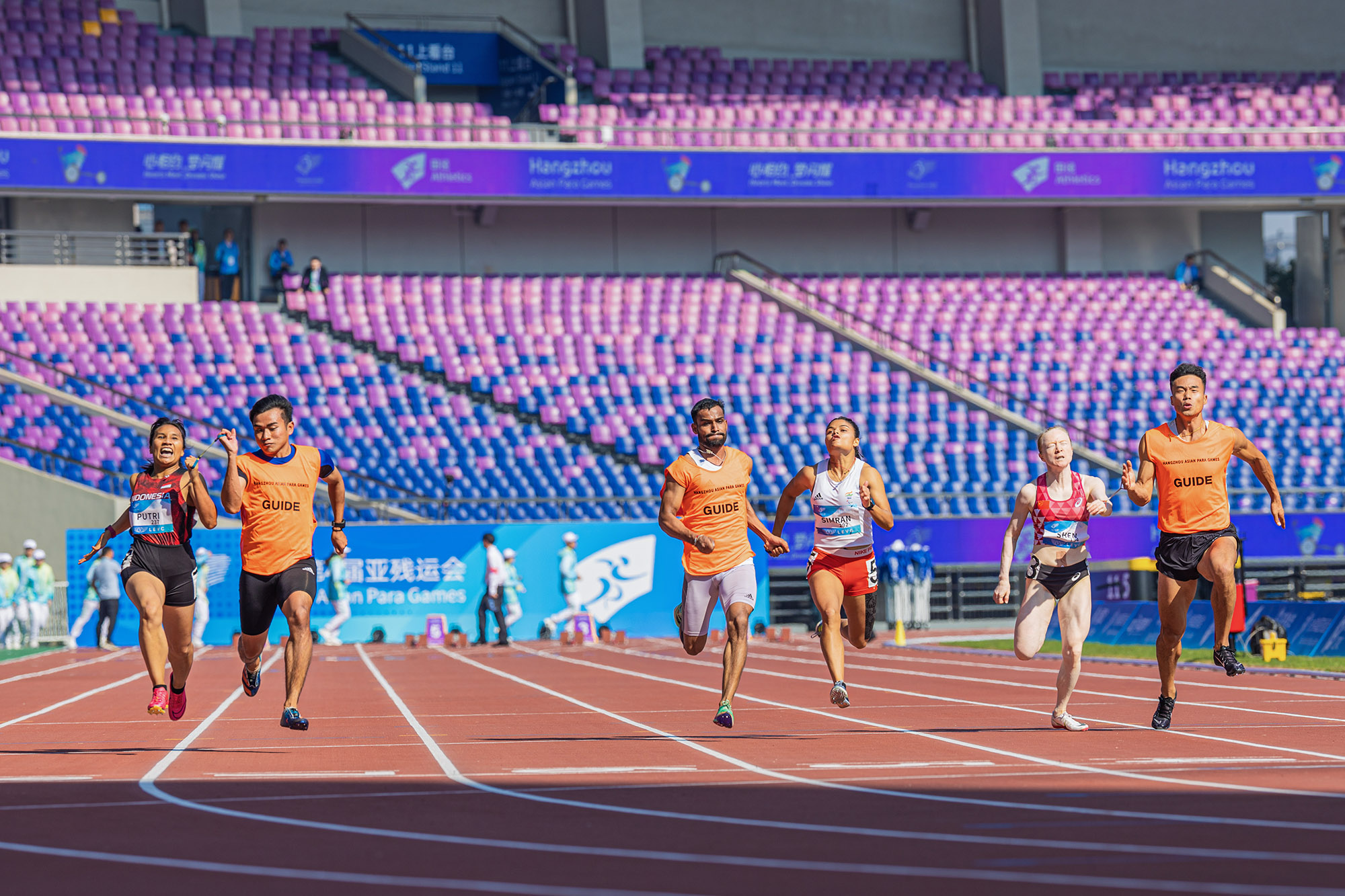Ni Made Arianti Putri (kiri) berusaha terdepan melintas garis finis dalam pertandingan nomor 100m T12 putri para atletik Asian Para Games Hangzhou 2022 di Huanglong Sports Center Stadium, Selasa (24/10/2023). Arianti berhasil meraih medali emas dengan cat