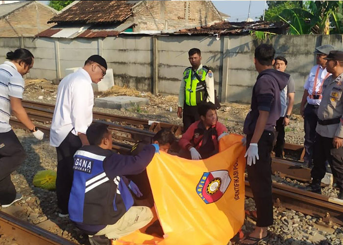 Polisi mengevakuasi jasad korban yang tersambar kereta api di perlintasan KA Stasiun Purwosari, Kamis (26/10).