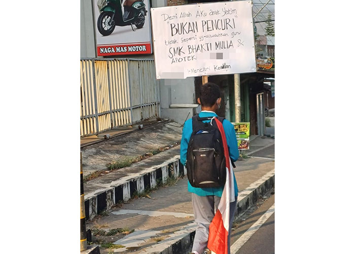 Foto yang beredar di media sosial, siswa SMK di Wonogiri jalan kaki membawa poster yang menegaskan bukan pencuri.