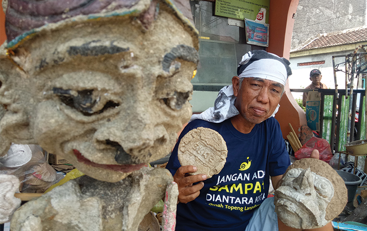 PEDULI LINGKUNGAN: Rus Hardjanto alias Mbah Jantit menunjukkan karya seni dari kertas koran.