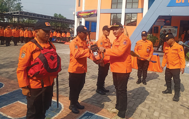 SIMBOLIS: Plt Bupati Karanganyar Rober Christanto menyerahkan alat untuk menangangi bencana ke relawan, kemarin.