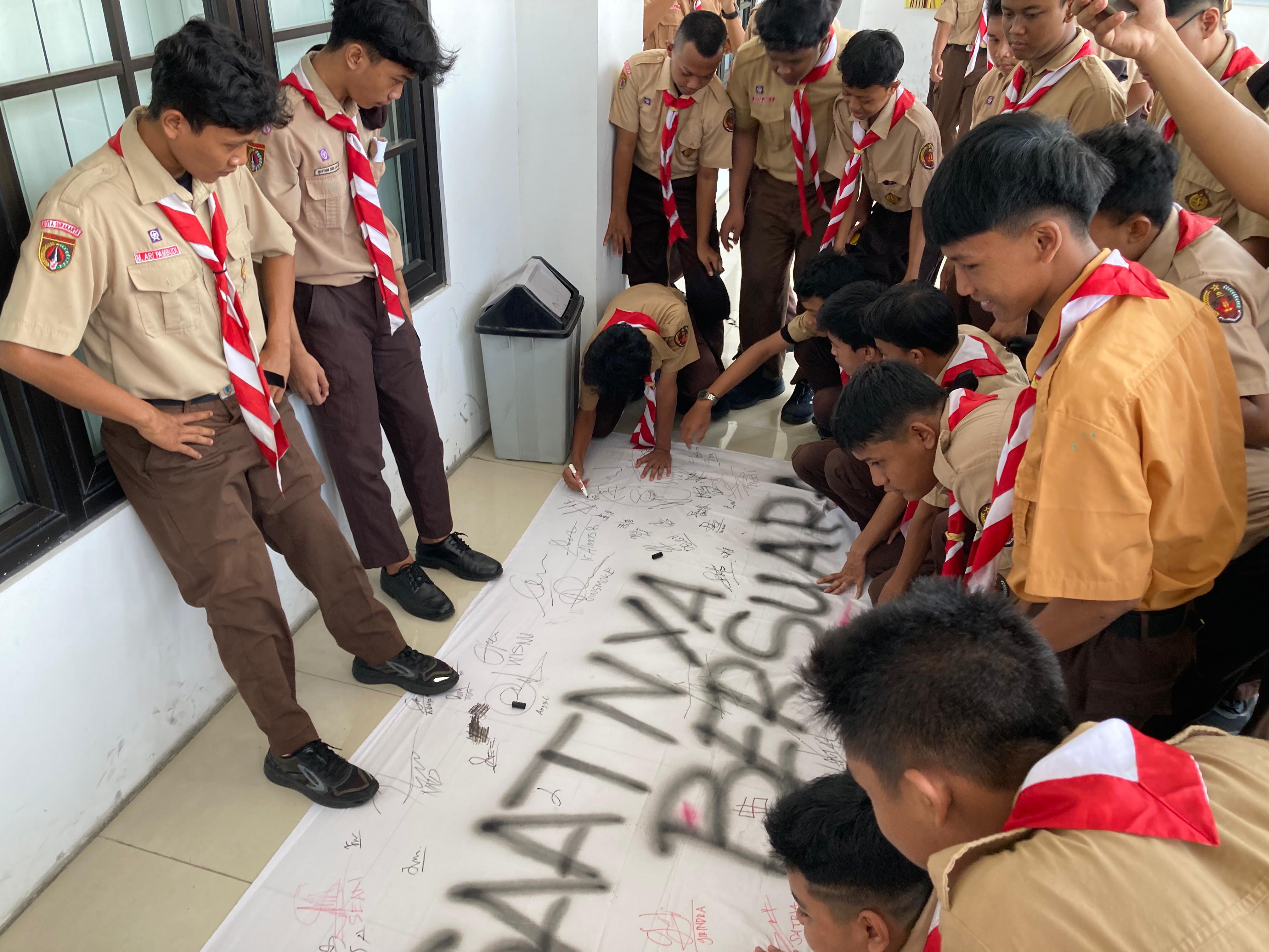GELAR AKSI PROTES: Para siswa SMKN 2 Surakarta menandatangi poster sebagai wujud aksi protes kepada pihak sekolah yang dirasa membatasi kegiatan dan mempersulit pendanaannya, Jumat (10/11)