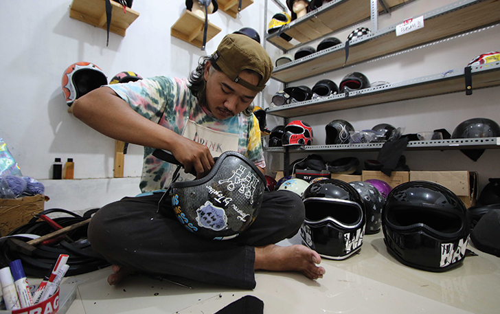 TAMPIL BEDA: Fariz Suryo Putro di rumah produksi helm custom miliknya di Gumpang, Kartasura, Sukoharjo, kemarin.