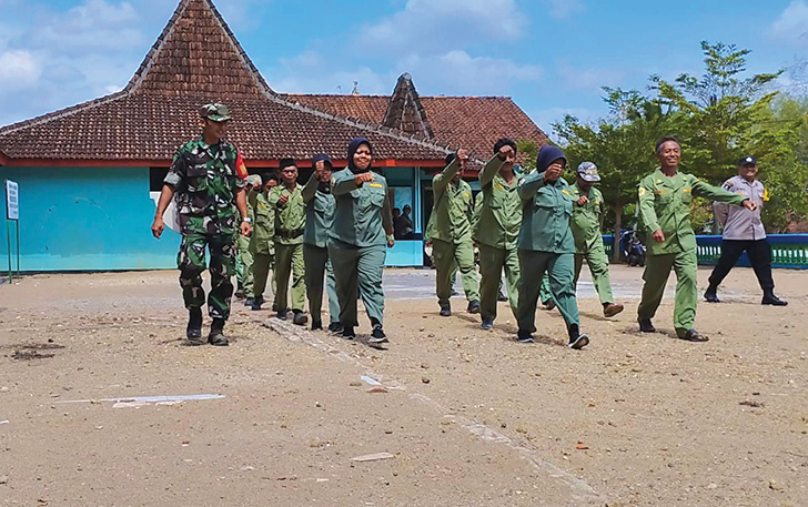 Ilustrasi anggota Linmas dilatih baris berbaris oleh anggota TNI-Polri
