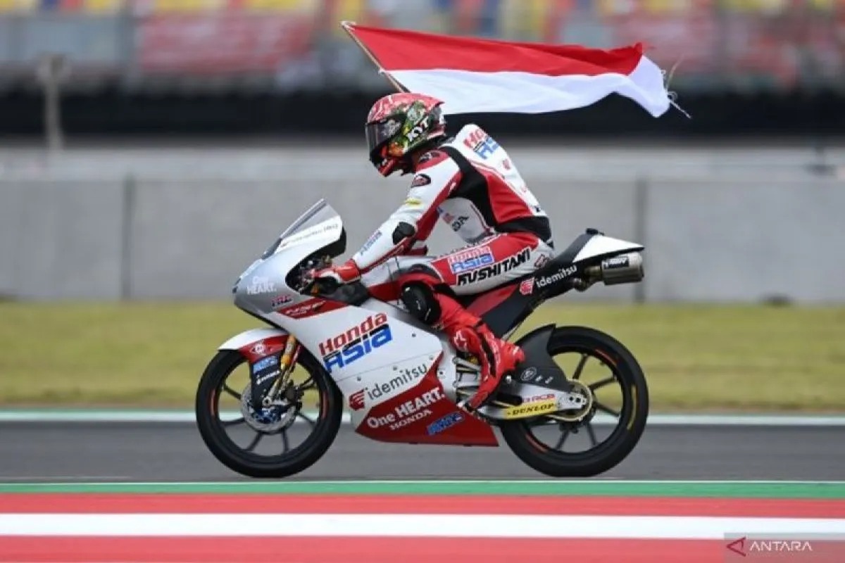 Pembalap Honda Team Asia Mario Suryo Aji membawa bendera merah putih seusai balapan Moto3 seri Pertamina Grand Prix of Indonesia di Pertamina Mandalika International Street Circuit, Lombok Tengah, NTB
