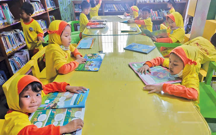 CERIA: Anak-anak PAUD di Sragen tengah melihat buku cerita di dalam kelas.