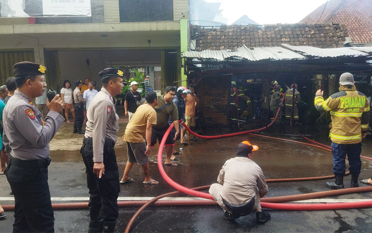Petugas Dinas Damkar Kota Solo dibantu Kepolisian dan warga setempat tengah memadamkan kebakaran yang melanda bengkel las di Jalan Dr Radjiman, No. 297 Panularan, Kecamatan Laweyan Senin (27/11).