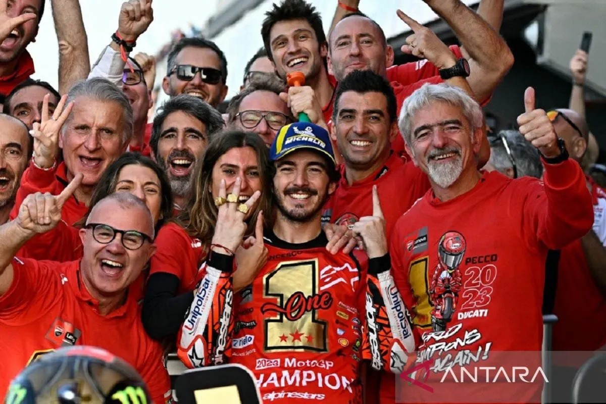 Pebalap Italia Francesco Bagnaia melakukan selebrasi bersama tim Ducati Lenovo setelah mempertahankan gelar juara dunia MotoGP dan memenangi Grand Prix Valencia di Sirkuit Ricardo Tormo, Valencia