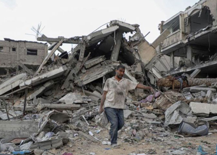 Warga memindahkan sebongkah reruntuhan bangunan yang hancur akibat serangan udara Israel di Kota Khan Younis di Jalur Gaza bagian selatan pada Minggu (12/11).
