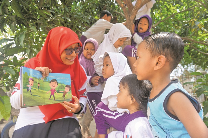 Pemerhati pendidikan anak usia dini (PAUD) asal Kabupaten Klaten Dwi Kurniasih saat mendongeng dengan membacakan buku cerita di salah satu PAUD di Kecamatan Ceper. ANGGA PURENDA/RADAR SOLO