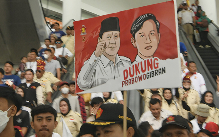 Seorang simpatisan membawa poster dukungan kepada pasangan capres cawapres Prabowo Gibran.