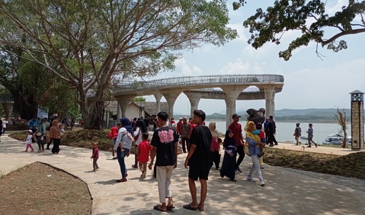Wisatawan menikmati keindahan objek wisata Waduk Gajah Mungkur, Senin (1/1/2024).