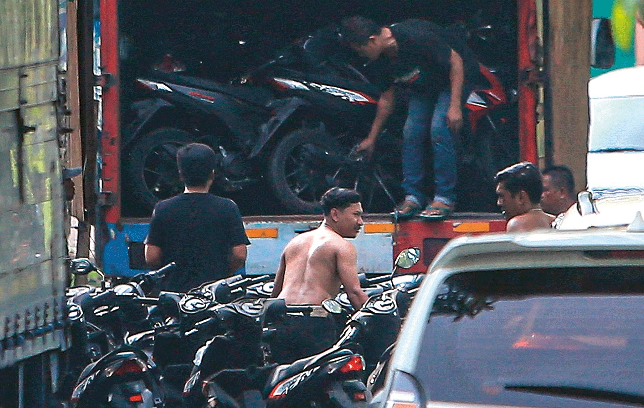 LACAK PENADAH: Petugas menaikkan kendaraan bermotor yang tersimpan di Gudbalkir Pusziad, Buduran, Sidoarjo, ke truk kontrainer, Sabtu (6/1).