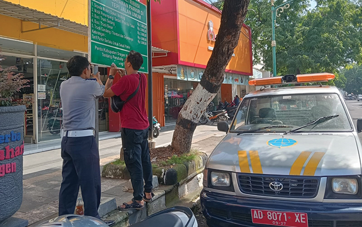 PENYESUAIAN: Petugas Dishub Sragen mengganti papan tarif parkir tepi jalan umum di Sragen.