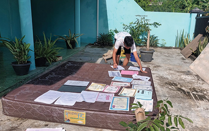 Seorang warga tengah menjemur sertifikat, ijazah, buku pasca banjir di Desa Sawahan akibat luapan Sungai Grenjeng, Jumat (12/1/2024).