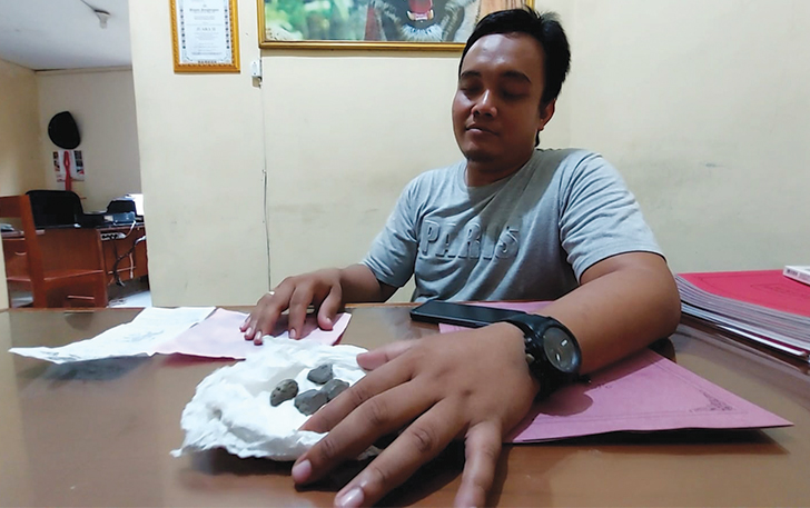 Petugas dari Polsek Cepogo menunjukkan bungkusan tisu dan yang berisi empat kerikil dan uang Rp 50 Ribu yang diberikan pada korban usai perhiasannya dirampok, Senin (15/1/2024).