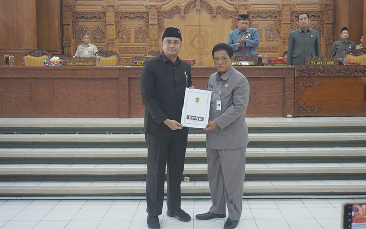 GERAK CEPAT; Ketua DPRD Klaten Hamenang Wajar Ismoyo menyerahkan dokumen perda tentang penanaman modal ke Wakil Bupati Klaten Yoga Hardaya, Senin (29/1)