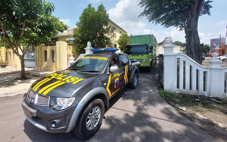 DIKAWAL KETAT: Mobil polisi mengawal distribusi kotak suara logistik Pemilu 2024 yang diangkut truk tronton dari gudang KPU Sukoharjo menuju gudang PPK Kartasura, kemarin (31/1).