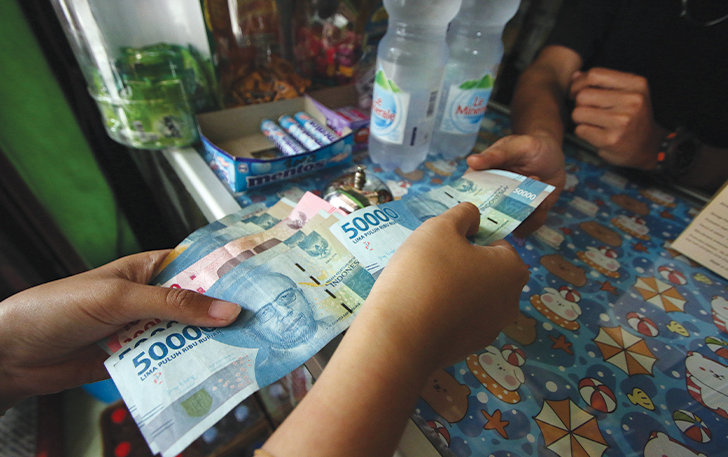 AMAN: Transaksi dengan uang tunai di salah satu toko kelontong.