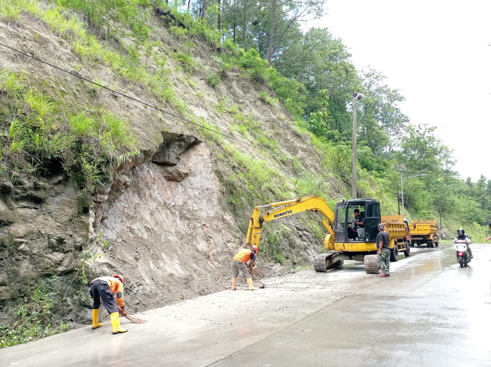 Upaya pembersihan sisa material longsor di jalan lingkar kota Wonogiri, Senin (5/2/2024).