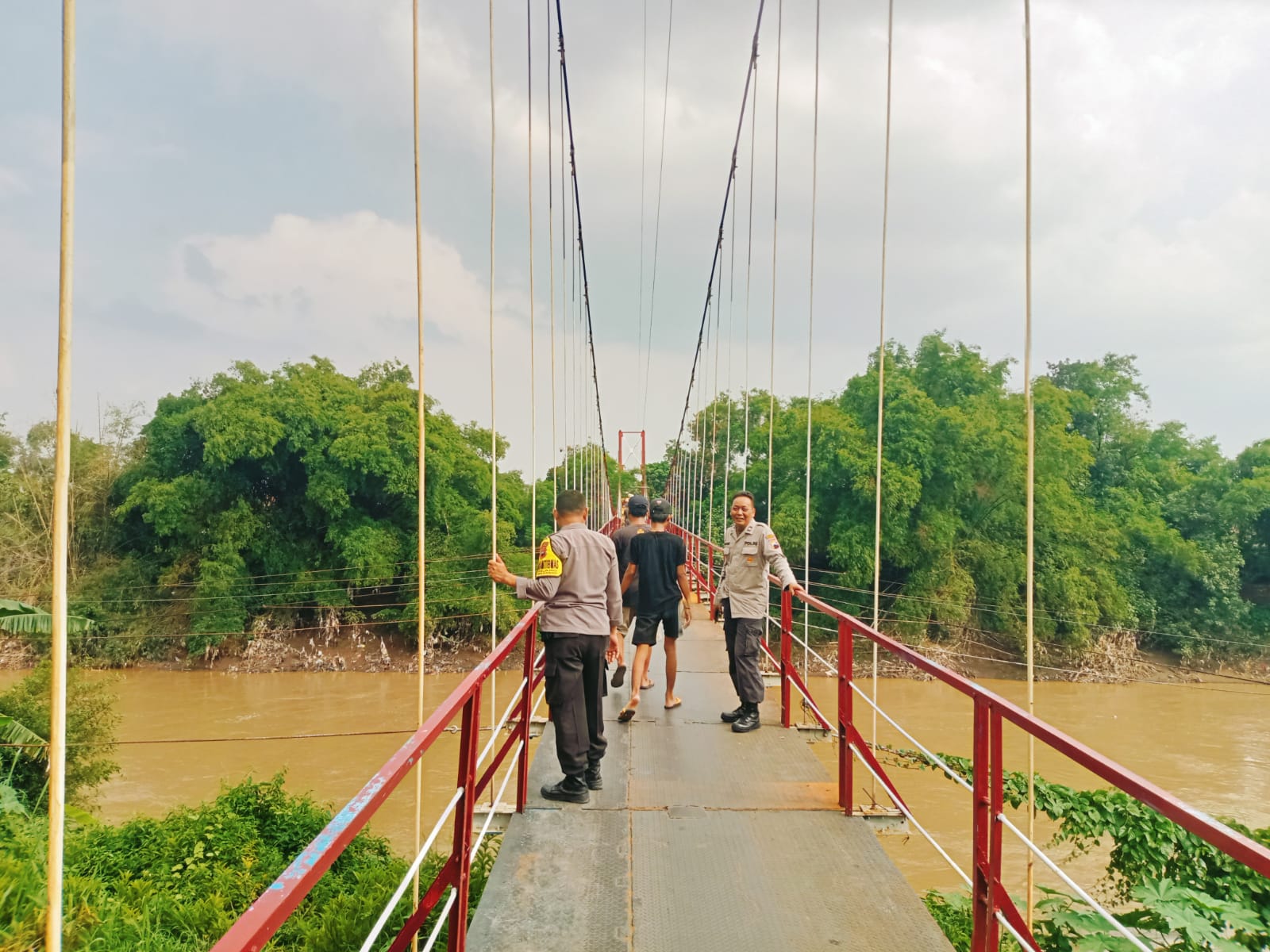 Anggota Polsek Masaran dan relawan mencari keberadaan Apin yang lompat dari jembatan gantung, Desa Kliwonan, Kecamatan Masaran, Kabupaten Sragen, Jumat (16/2/2024).