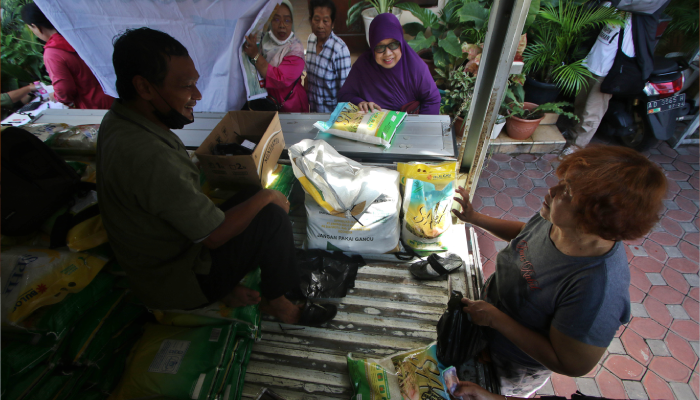 Masyarakat membeli beras dalam operasi pasar yang digelar di Pasar Kadipolo, Solo.