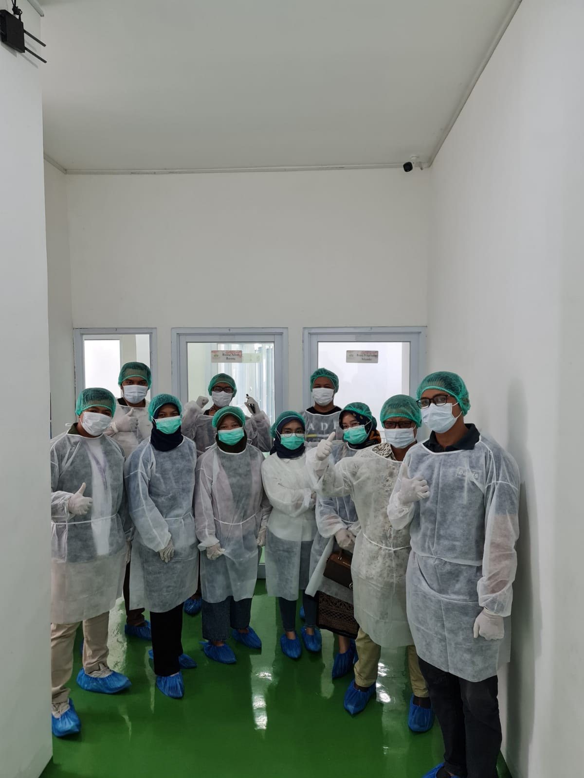 Peserta pelatihan mengenakan APD saat tur pabrik produk herbal.
