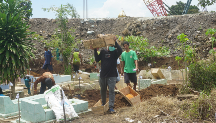 Sejumlah pekerja dari Al Iswat yang sedang melakukan pembongkaran makam di tengah ruas Jalan Tol Solo-Jogja di Desa Beku, Kecamatan Karanganom, Klaten, Selasa (27/2).