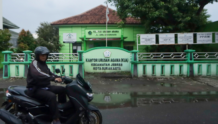 Warga melintas di depan KUA Kecamatan Jebres, Solo, Rabu (28/2).
