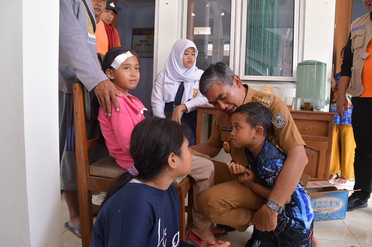 Pj Bupati Karanganyar Timotius Suryadi berinteraksi dengan anak-anak yang terdampak longsor di Kecamatan Jenawi, Selasa (5/3/2024).