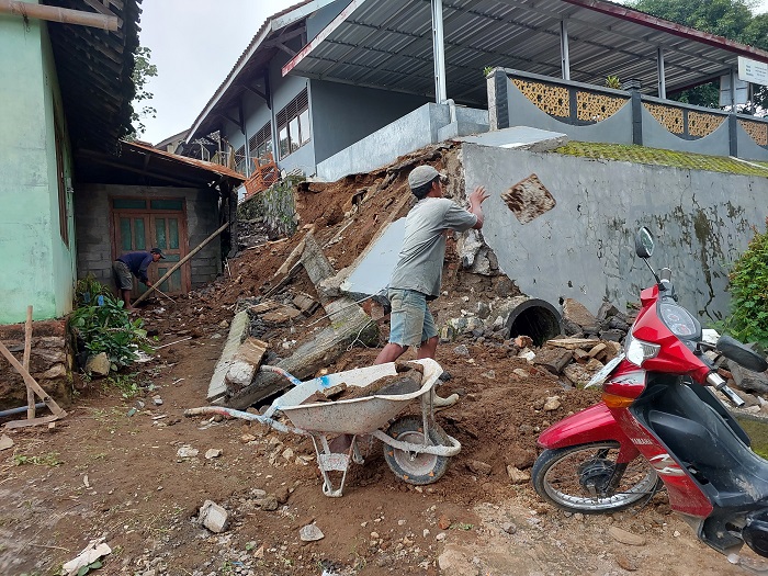 Pekerja membersihkan puing-puing sisa longsor talut pagar SMPN 1 Gladasari Boyolali, Rabu (6/3/2024).