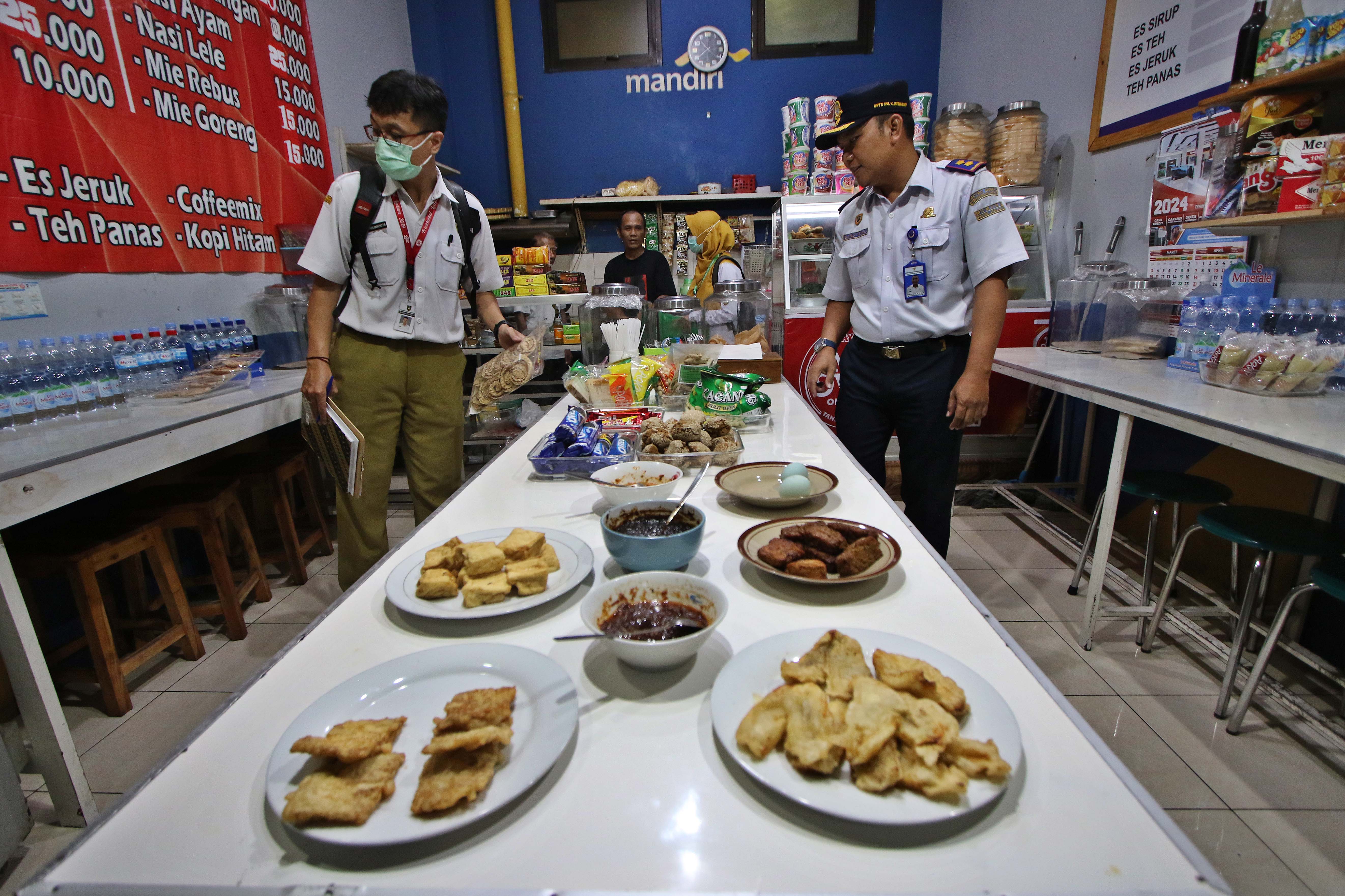 Petugas mengecek kondisi makanan dan oleh-oleh yang dijual di beberapa warung di Terminal Tirtonadi, Kamis (21/3/2024).