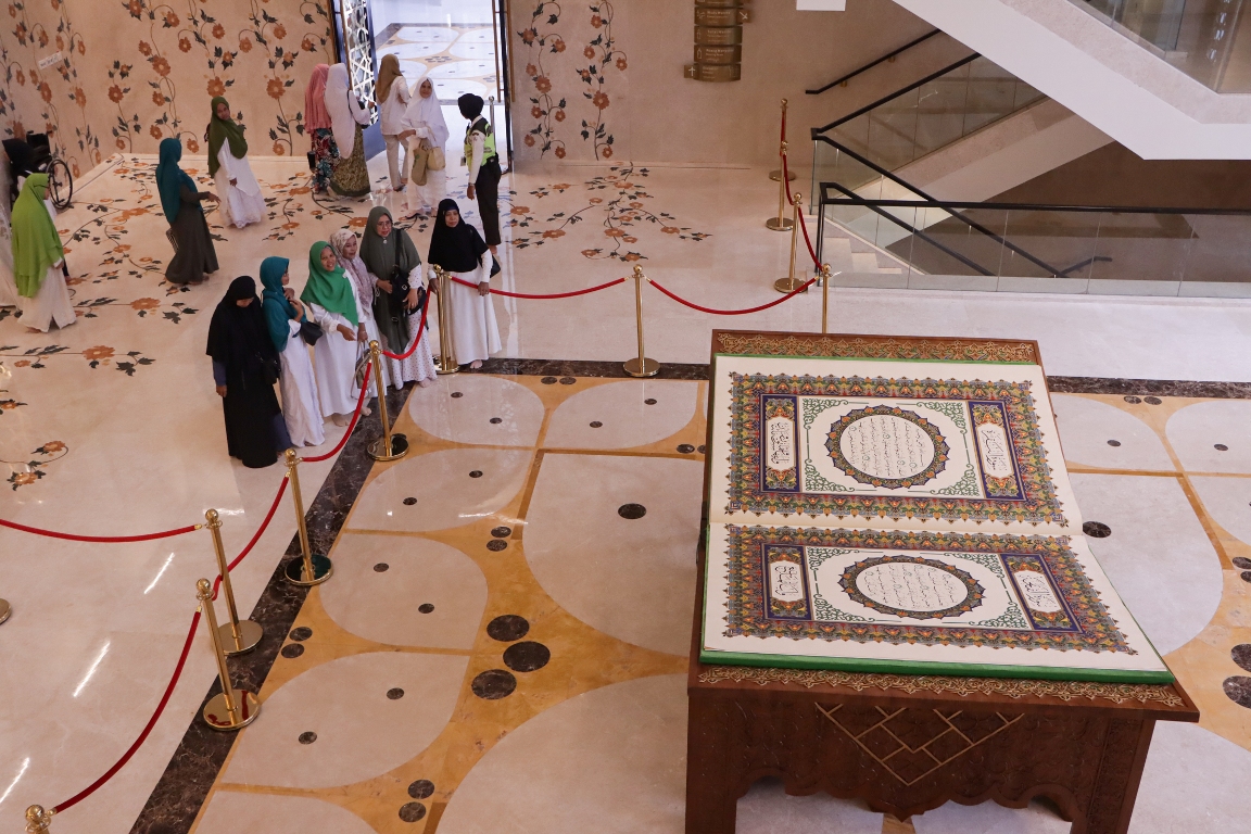 Pengunjung Masjid Raya Sheikh Zayed Solo melihat Alquran raksasa di dalam masjid setempat, kemarin (24/3/2024). (M.Ihsan/Radar Solo)