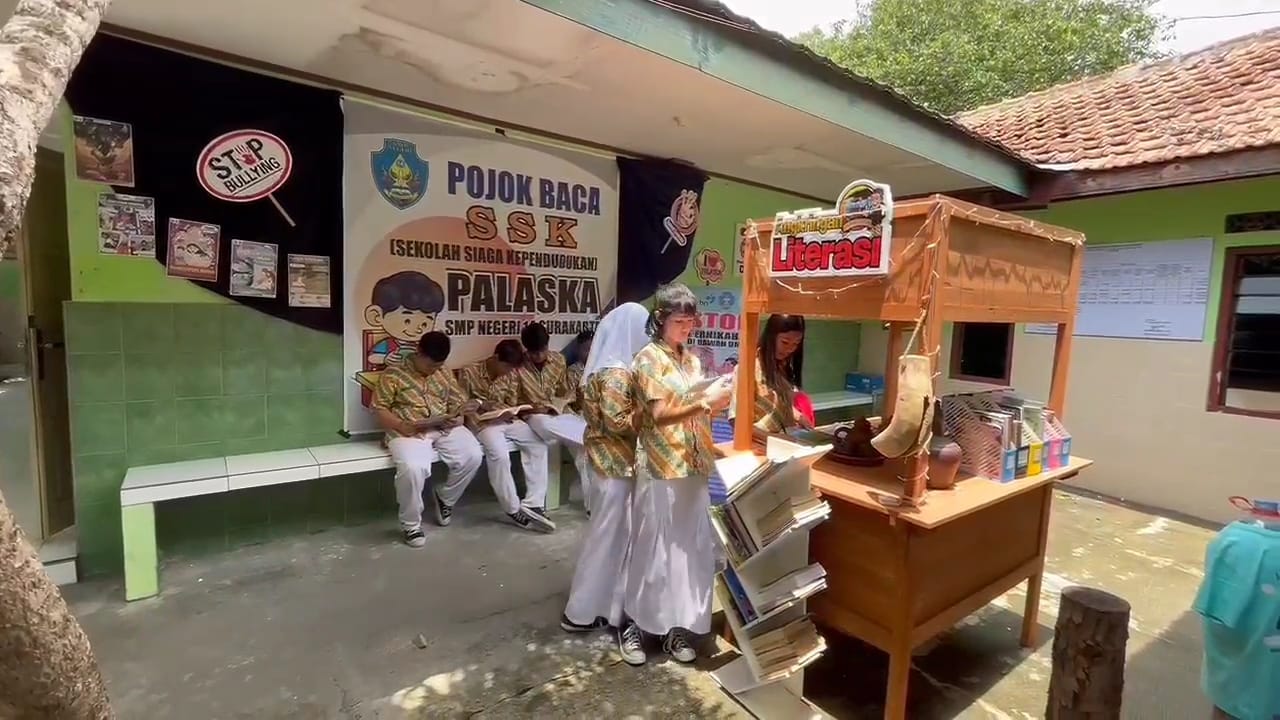 Siswa membaca buku di angkringan literasi sekolah.