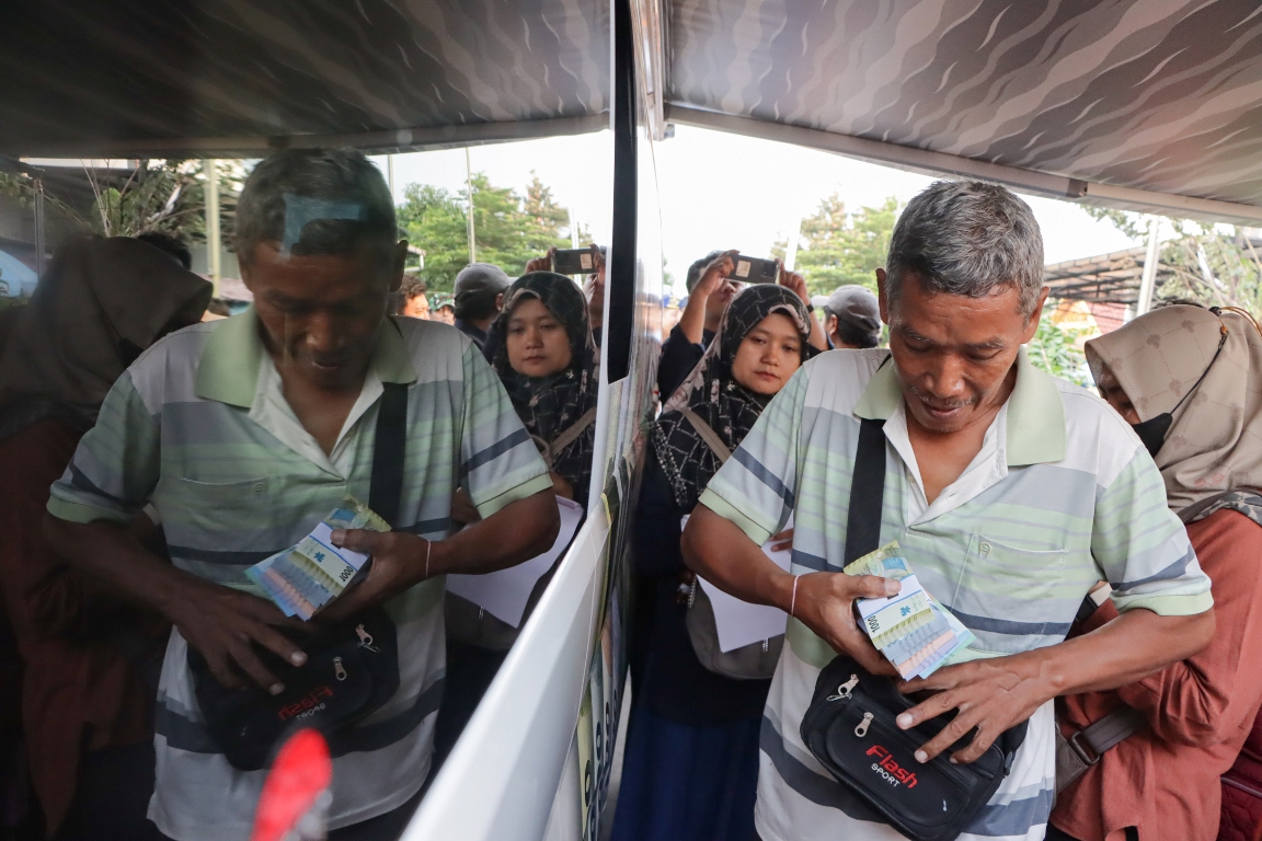 Warga menukarkan uang pecahan di gerai yang disediakan di halaman Masjid Raya Sheikh Zayed Solo, Kamis (21/3/2024). (M.Ihsan/Radar Solo)