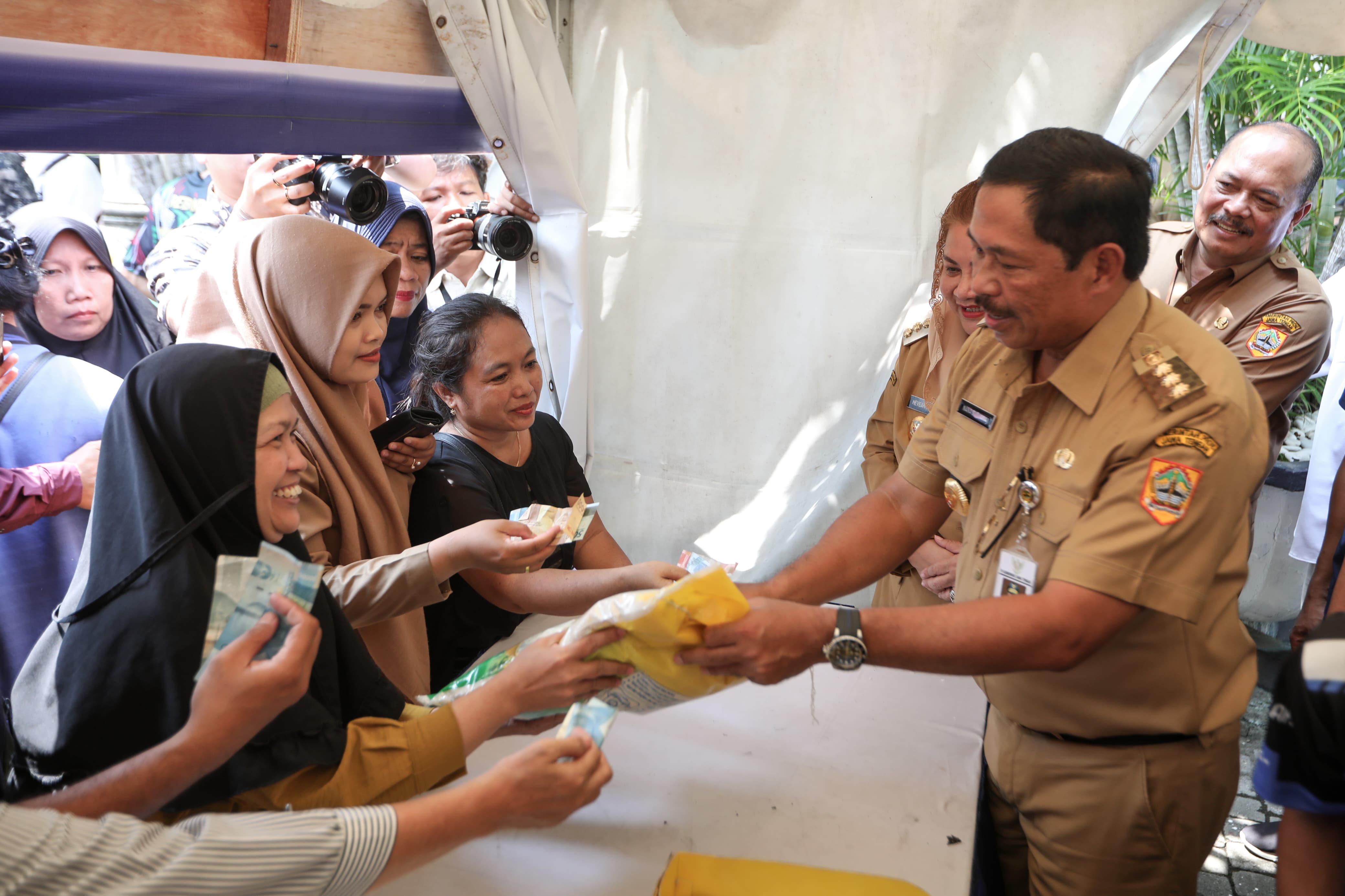 Pj Gubernur Jateng Nana Sudjana layani masyarakat yang membeli bahan pokok pada program Gerakan Pangan Murah belum lama ini.