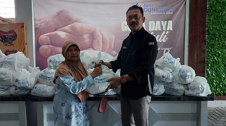 Direktur Utama Bank Guna Daya Arry Mardiyanto menyerahkan bantuan paket sembako kepada masyarakat.