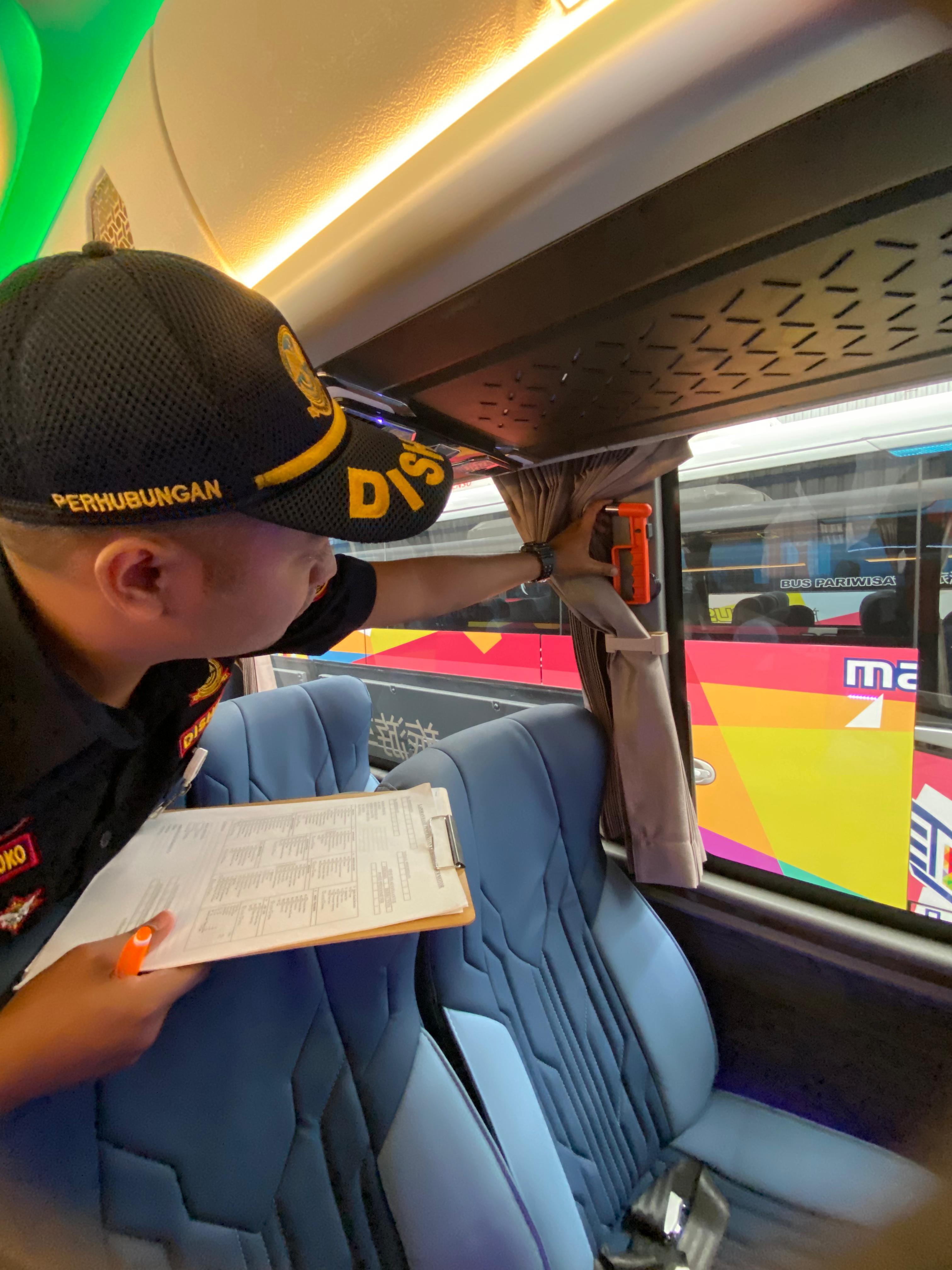 petugas dishub melakukan pengecekan fasilitas keamanan di dalam bus yang akan digunakan untuk arus mudik.